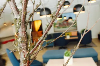 a tree in an office with a table and chairs at Trudvang Apartment Hotel in Rena