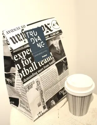 a newspaper and a cup of coffee on a table at Trudvang Apartment Hotel in Rena