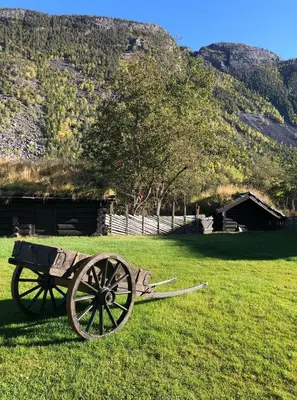 a wooden cart sitting in the grass in a field at Jørundgard Vikingcamp in Sel