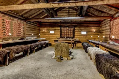 a large room with rows of chairs in a wooden building at Jørundgard Vikingcamp in Sel