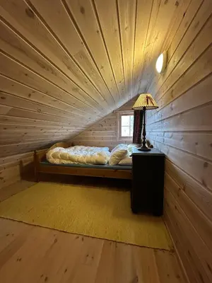 a bed in a room with a wooden ceiling at Family cabin in Hafjell, ski in-ski out in Hafjell