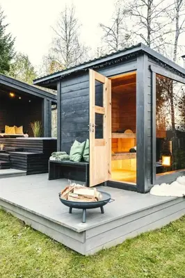 a black tiny house with a open door at Modern Cottage With River Frontage Near Opphus in Rena