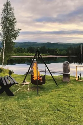 a swing with a fire hydrant on it next to a lake at Modern Cottage With River Frontage Near Opphus in Rena
