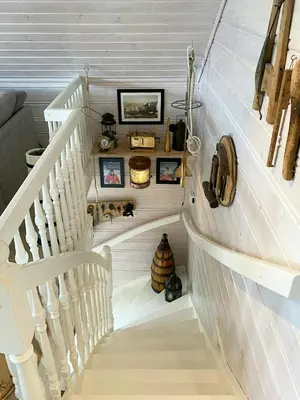 a white staircase with some pictures on the wall at Fishermen's Cabin With Sea View in Bømlo