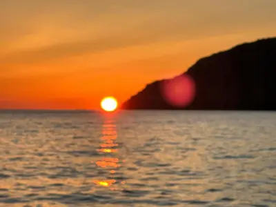 a sunset over the ocean with the sun setting at Fishermen's Cabin With Sea View in Bømlo