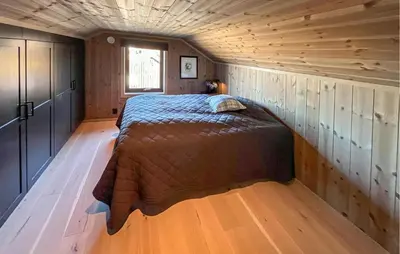 a bedroom in a log cabin with a bed in it at Amazing Home In Røn With Sauna in Ron