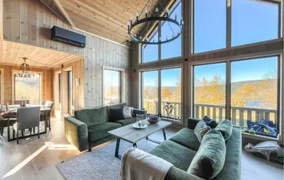 a living room with couches and a table and windows at Amazing Home In Røn With Sauna in Ron