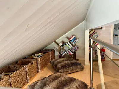 a attic room with two ottomans and a staircase at TexasToppen, cabin in Hafjell with sauna in Hafjell