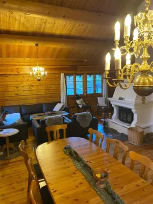 a living room with a table and a fireplace at Holmøy Lodge in Holmøyane