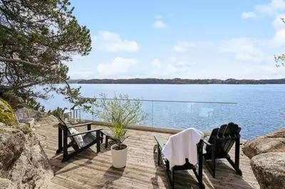 a deck with two chairs and a view of the water at RVH29 - Fjord Hideaway Villa in Veland