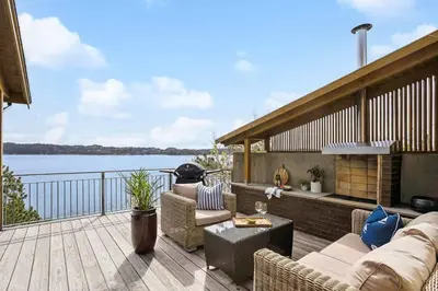 a patio with a couch and chairs on a deck at RVH29 - Fjord Hideaway Villa in Veland