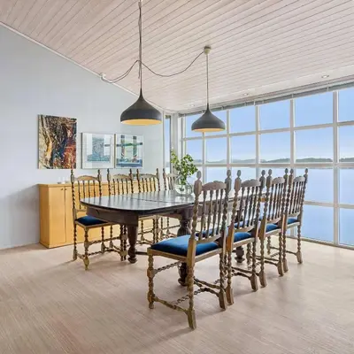 a dining room with a table and chairs and windows at RVH29 - Fjord Hideaway Villa in Veland