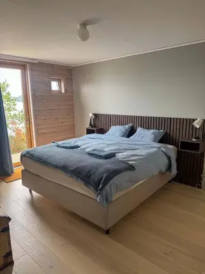 a bedroom with a large bed with a wooden headboard at RVH29 - Fjord Hideaway Villa in Veland