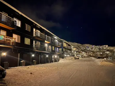 a snow covered street in front of a building at night at Hemsedal, Ski-in ski-out, Skarsnuten Panorama in Hemsedal