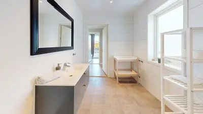 a bathroom with a sink and a mirror at Ocean view and jacuzzi in Forland