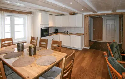 a kitchen and dining room with a wooden table at Lovely Home In Sjusjøen With Sauna in Sjusjøen