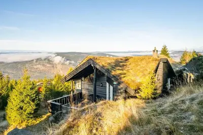 an old house with a grass roof on a hill at Bekkeblom, family cabin with extension in Hafjell in Hafjell