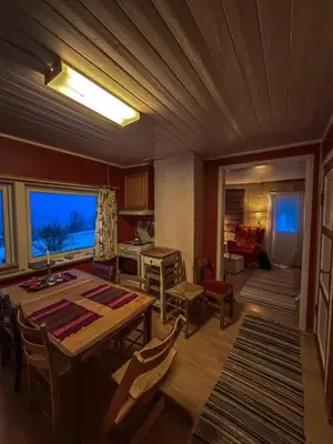 a living room with a table and a dining room at Charming Norwegian Cottage in Lyngen
