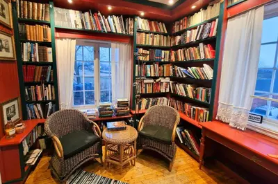 a library with two chairs and shelves of books at Torshov Gård, Viking grounds in Hamar