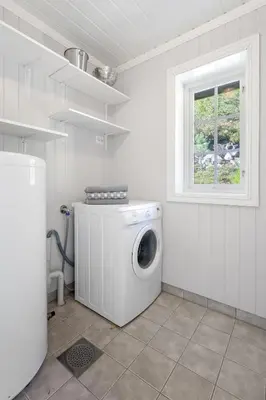a washing machine in a white room with a window at Luxury cabin with amazing views in Stryn