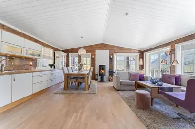 a kitchen and living room with a table and a couch at Luxury cabin with amazing views in Stryn