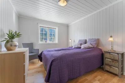 a bedroom with a purple bed and a chair at Luxury cabin with amazing views in Stryn