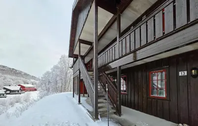 a building with snow on the side of it at Amazing Apartment In Edland With House Sea View in Nesland