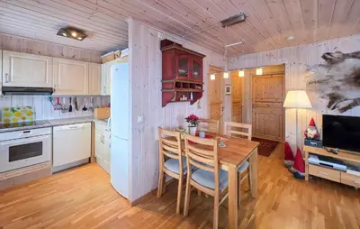 a kitchen with a wooden table and a refrigerator at Amazing Apartment In Edland With House Sea View in Nesland