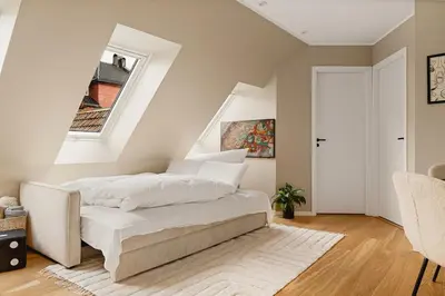 a bedroom with a white bed and a window at Modern apartment on Bryggen Walking distance to everything! in Bergen