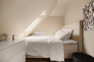 a bedroom with a white bed in a attic at Modern apartment on Bryggen Walking distance to everything! in Bergen