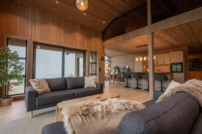 a living room with two couches and a table at Luxury cabin, Wellness and view over the Tyrifjord in Vikersund