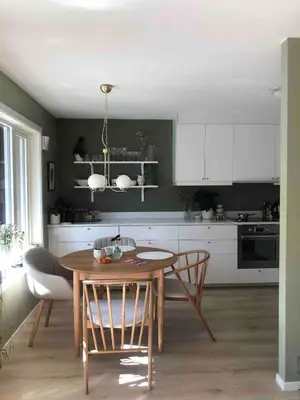 a kitchen with a wooden table and chairs in a room at Newly renovated 3-room apartment in Bergen