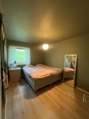 a bedroom with a bed and a mirror in it at Newly renovated 3-room apartment in Bergen