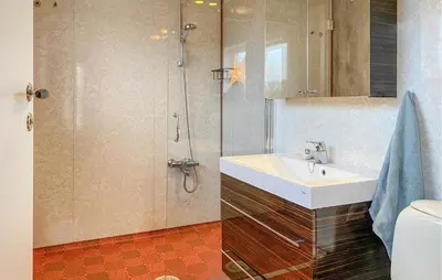 a bathroom with a sink and a shower at Nice Home In Harøya With Harbor View in Steinshamn