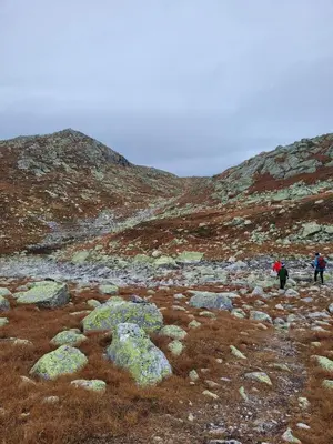 two people walking on a rocky hillside with rocks at Family-friendly cabin at Høgevarde! in Flå