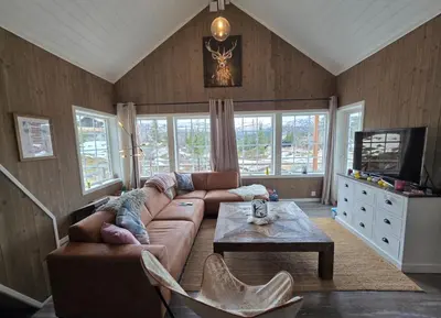 a living room with a couch and a table at Family-friendly cabin at Høgevarde! in Flå