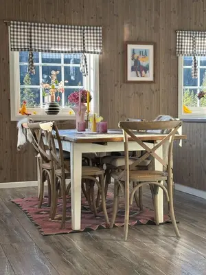 a dining room table and chairs in a room with a table at Family-friendly cabin at Høgevarde! in Flå