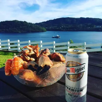 a bowl of seafood on a table next to a can of beer at House with oceanview, 4 bedrooms, close to Bergen in Alversund