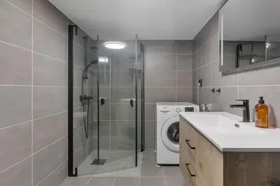 a bathroom with a shower and a washing machine at Vestbyvegen 34A By Vacation Trysil in Trysil