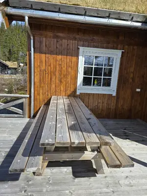 a wooden bench sitting in front of a building at Cozy Cabin Retreat in Fl, Norway - Perfect for Families and Nature Lovers in Flå