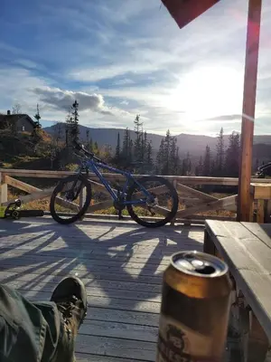 a bike parked on a wooden deck with a drink at Cozy Cabin Retreat in Fl, Norway - Perfect for Families and Nature Lovers in Flå