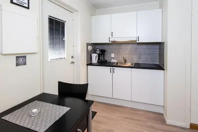 a small kitchen with white cabinets and a table at Rjukan Hytteby in Rjukan
