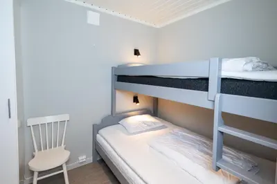 a small bedroom with bunk beds and a chair at Rjukan Hytteby in Rjukan