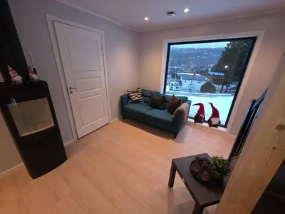 a living room with a couch and a large window at House with great location in Trysil