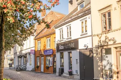 a street in a town with shops and buildings at Stylish apt 2nd floor city centre in Trondheim