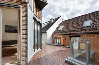 a large deck with glass windows in a house at Stylish apt 2nd floor city centre in Trondheim
