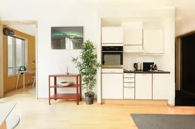 a kitchen with white cabinets and a potted plant at Stylish apt 2nd floor city centre in Trondheim