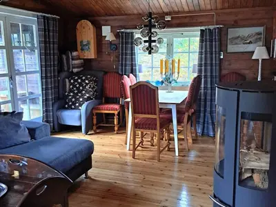 a living room with a table and chairs and a couch at 8 person holiday home in Jordet in Jordet