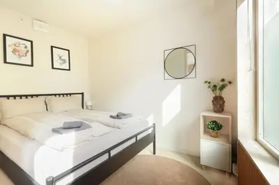 a white bedroom with a bed and a mirror at Elegant 1-Bed Apt in City Centre in Trondheim