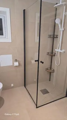 a shower with a glass door in a bathroom at Apartament Vigra Fjord in Synes